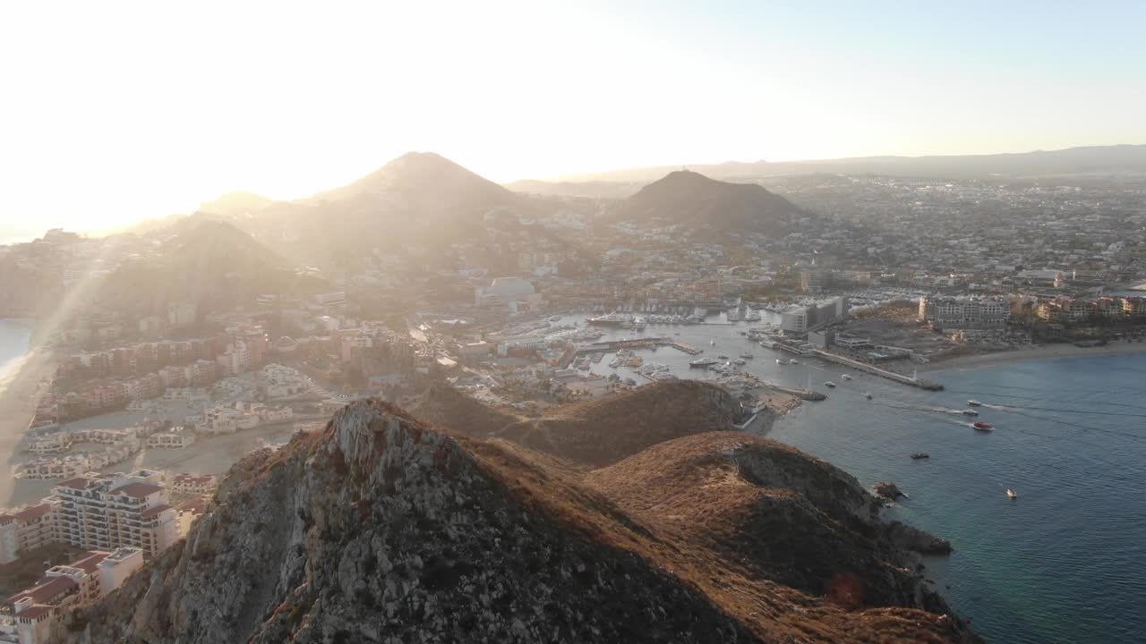 墨西哥卡波。梅达诺湾、度假村、山脉和日落时的码头的高空鸟瞰图。在岩石峭壁上淘金。4K Mavic 2 Zoom视频下载