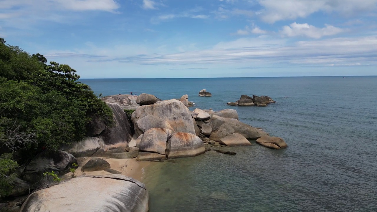 沿着泰国苏梅岛的海滩拍摄，岩石海岸和清澈的蓝色大海视频素材