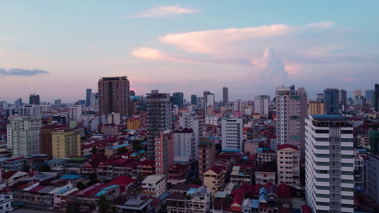 夕阳西下的金边市，无人机拍摄的背景是高楼大厦和令人印象深刻的天空，镜头向右平移视频素材