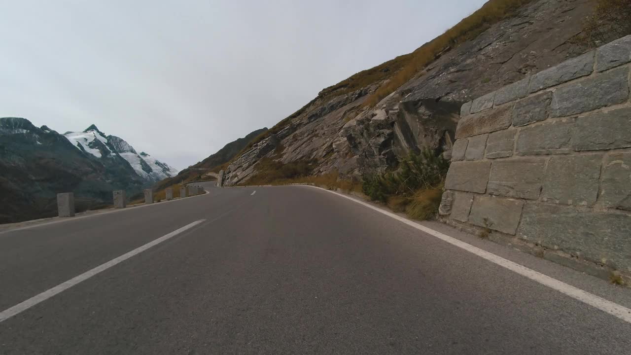 乘车观景，雄伟的大格洛克纳山路在奥地利，尖峰的高山山脉。跑车或自行车沿着奥地利阿尔卑斯山脉雄伟美丽的山路行驶视频素材