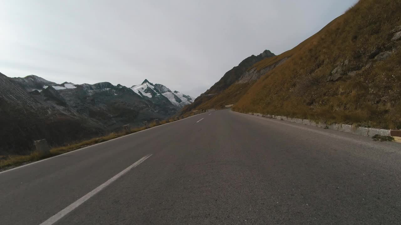 乘车观景，雄伟的大格洛克纳山路在奥地利，尖峰的高山山脉。跑车或自行车沿着奥地利阿尔卑斯山脉雄伟美丽的山路行驶视频素材