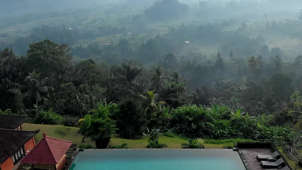 空中飞行的视频边缘的无限游泳池与火山视图在豪华别墅在丛林高地。巴厘岛。视频下载