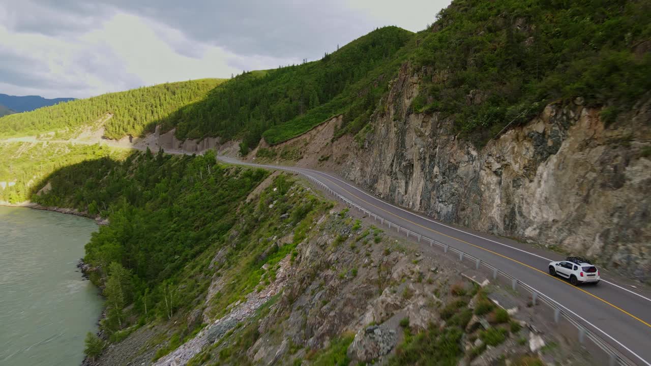 一辆汽车正沿着森林附近的山路行驶视频素材