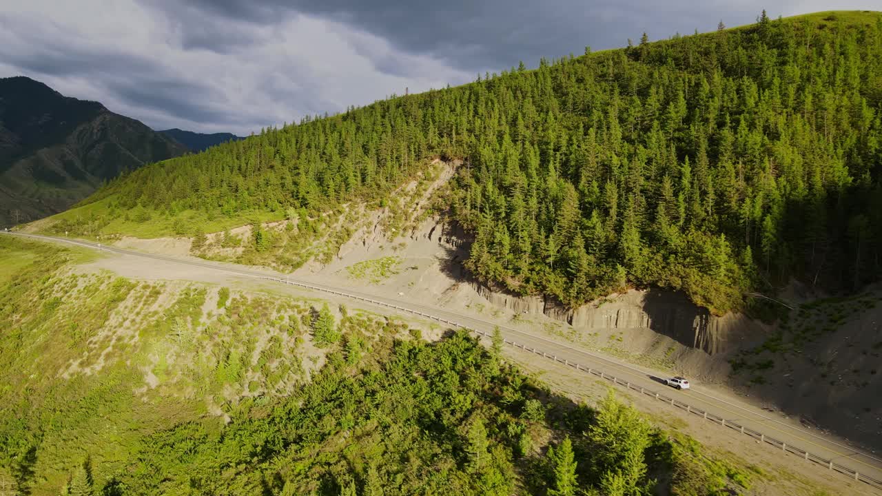 一辆汽车正沿着森林附近的山路行驶视频素材