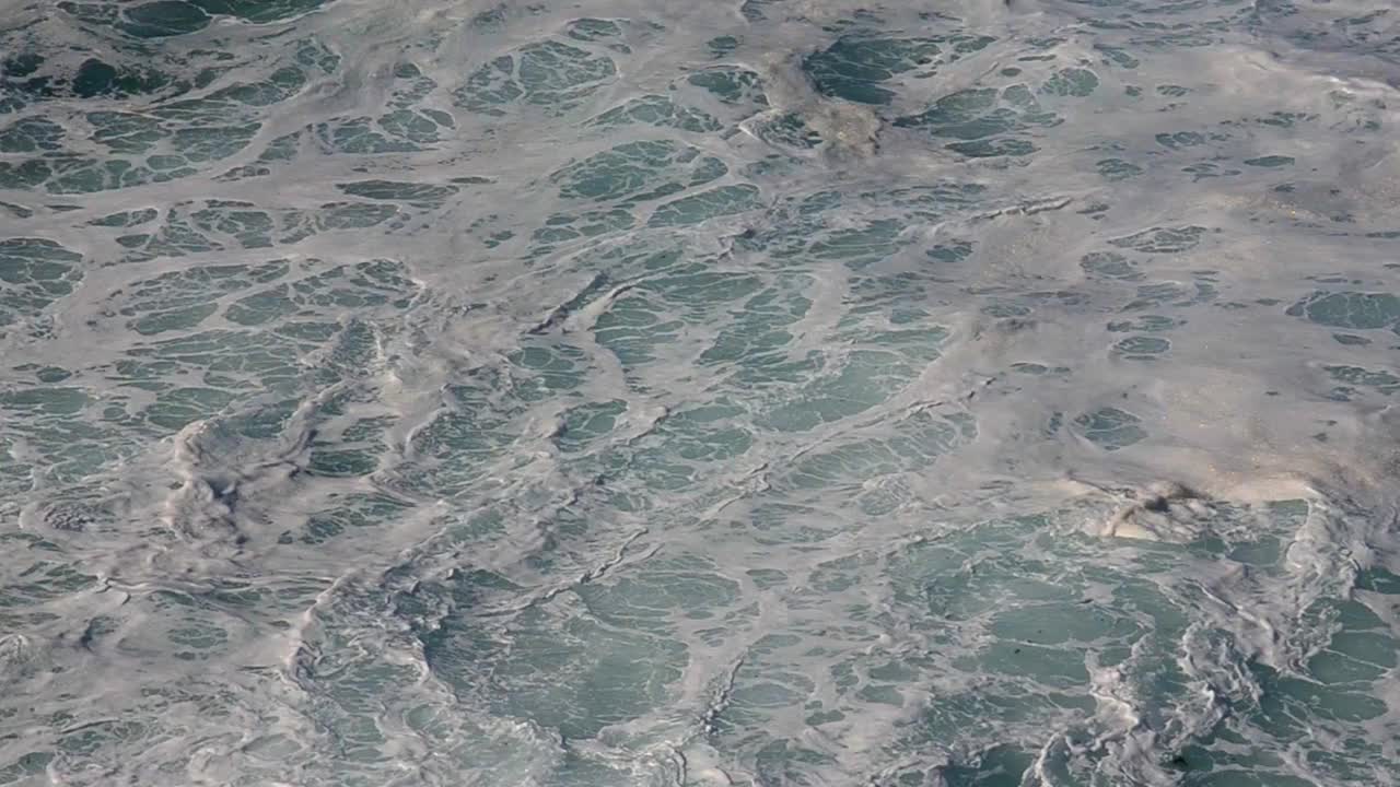 抽象的蓝色海水与白色泡沫背景。海浪纹理视频素材