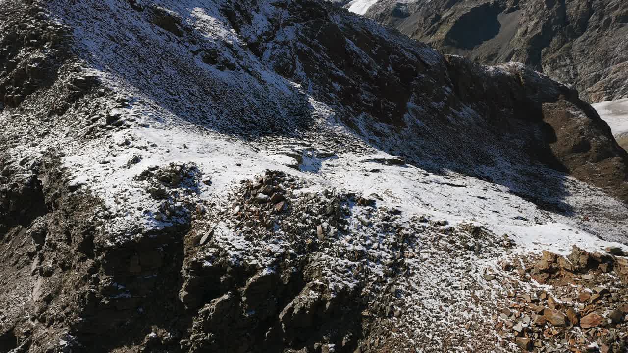 在夏季的阳光明媚的日子里，雪山山顶。空中无人机视频素材