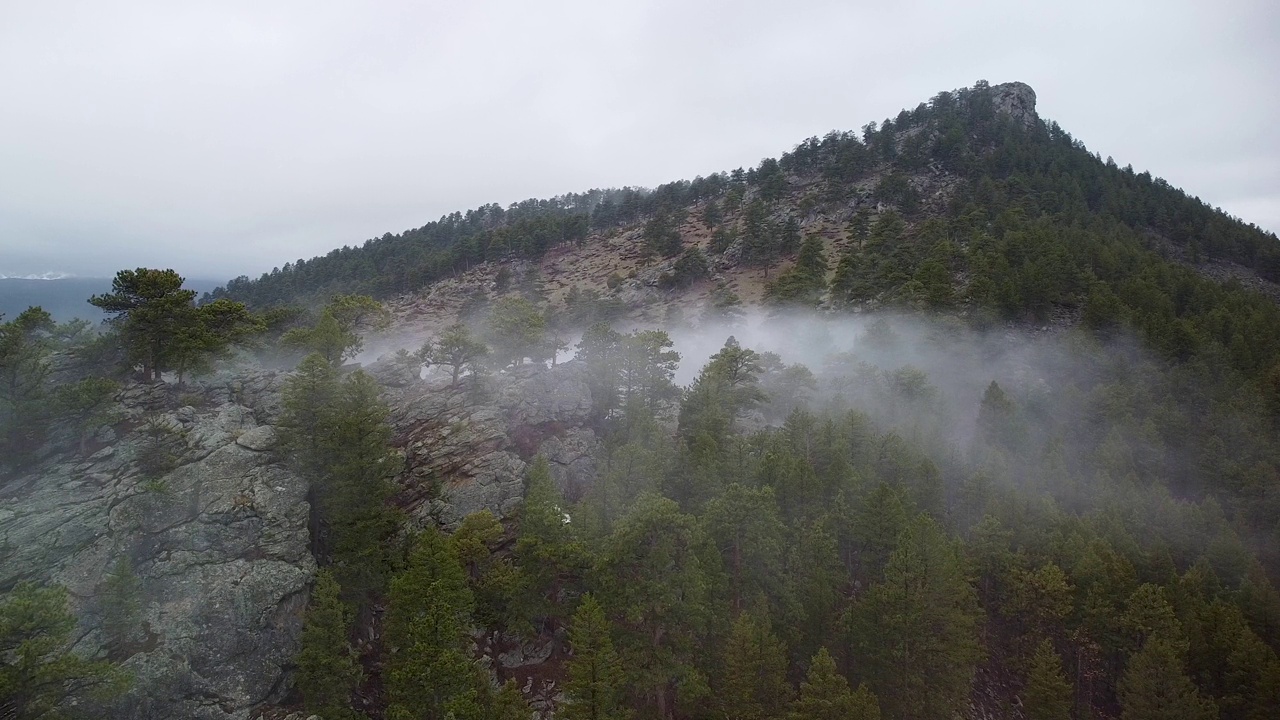 在鹰崖山，埃斯蒂斯公园，科罗拉多州的岩石山脊上爬行的雾的鸟瞰图视频素材