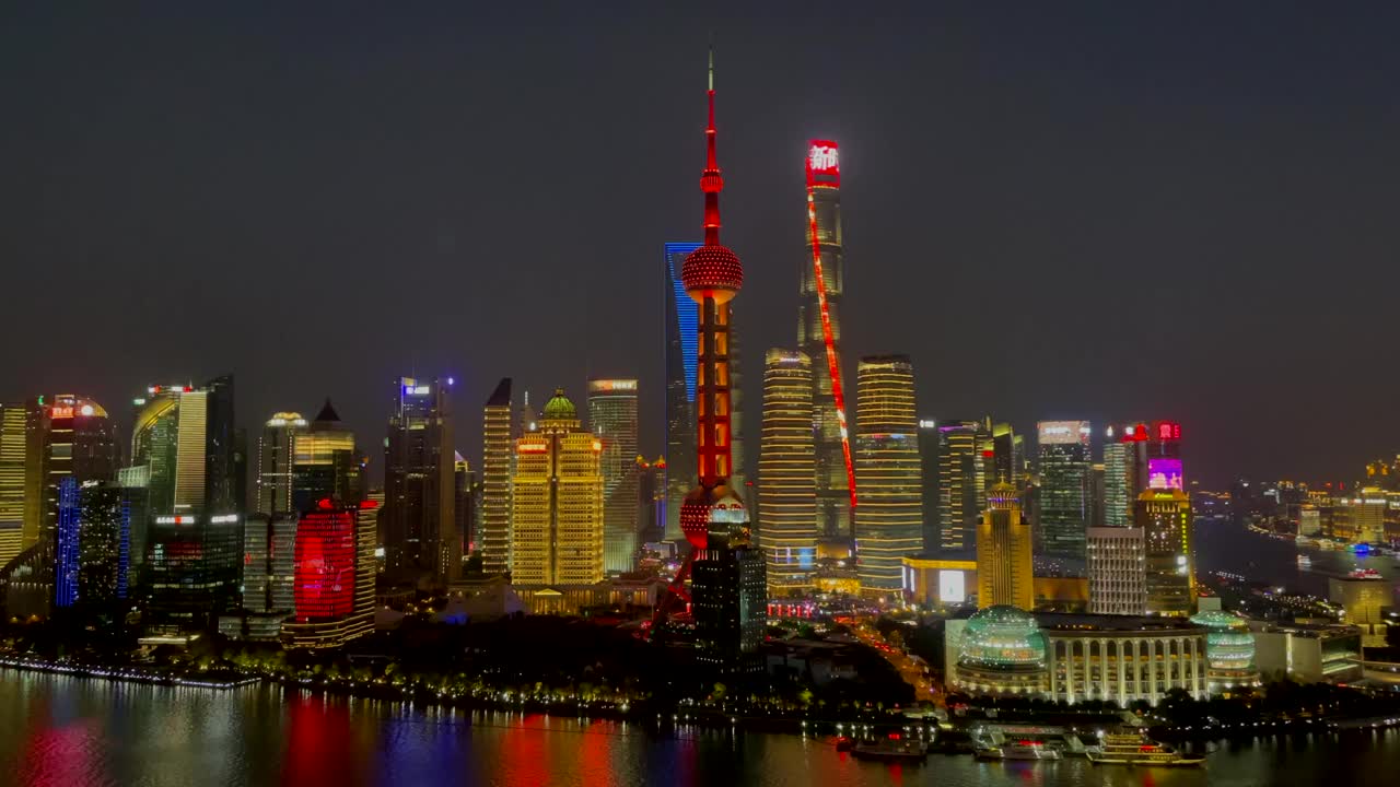 上海陆家嘴全景夜景，五彩缤纷的游船驶过黄浦江，天际线被灯光照亮。汉字翻译成“新时代，城市让生活更美好”视频素材