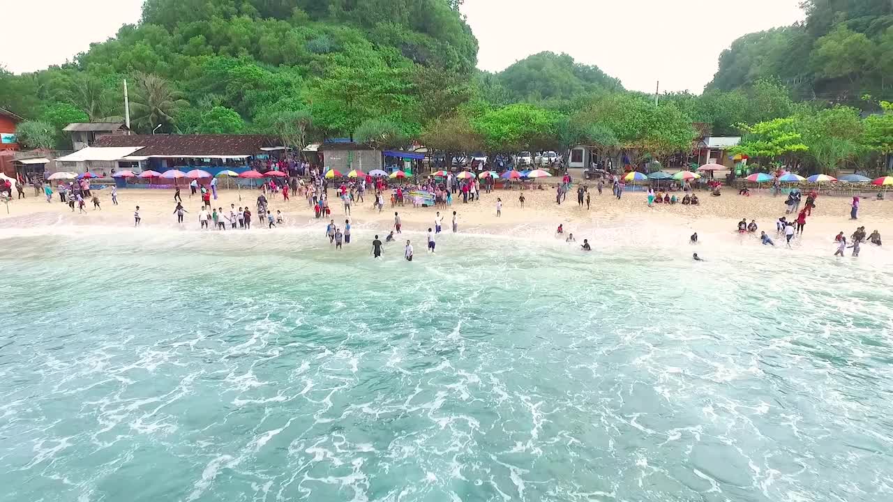 鸟瞰图Indrayanti海滩，日惹-印度尼西亚，蓝色海洋的印度尼西亚海滩，许多人前往海滩视频素材