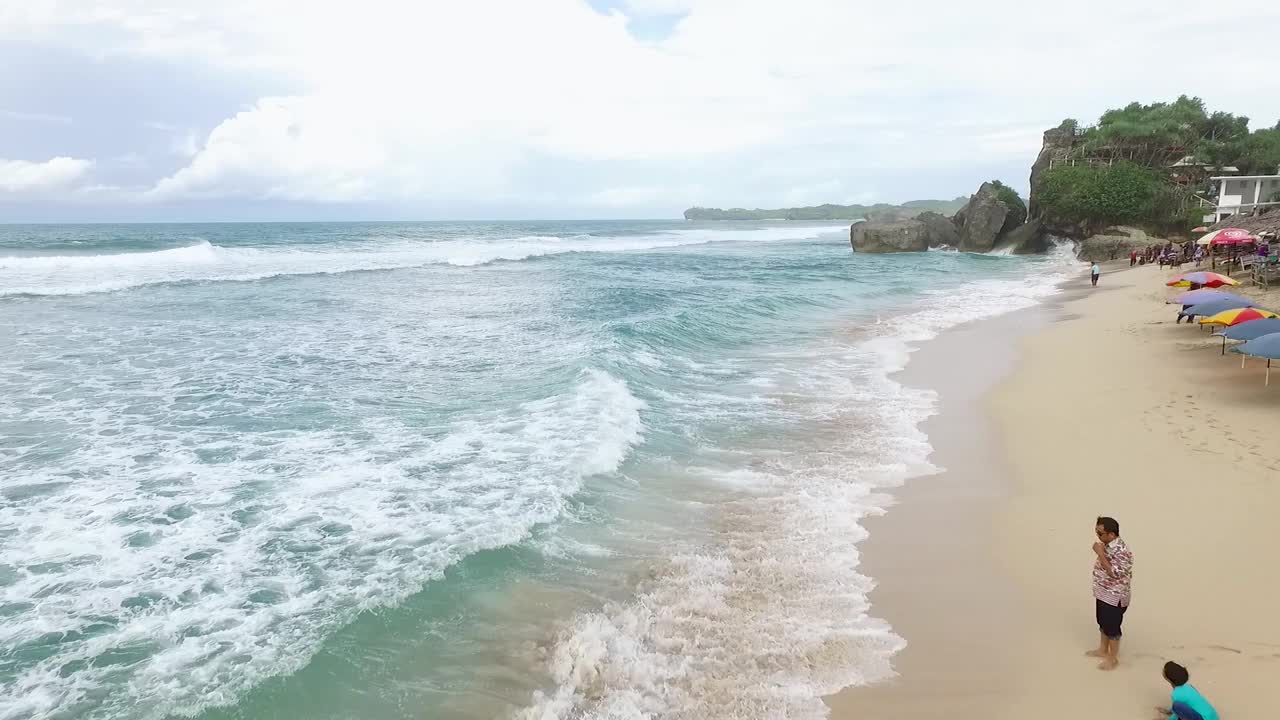 鸟瞰图Indrayanti海滩，日惹-印度尼西亚，蓝色海洋的印度尼西亚海滩，许多人前往海滩视频素材