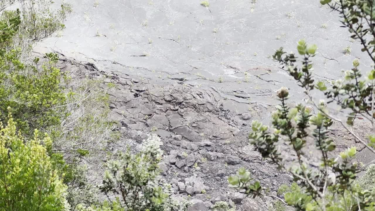 从夏威夷火山国家公园基拉韦厄伊基干熔岩湖床上的徒步小径俯瞰的电影长镜头，4K HDR, 30帧/秒视频素材