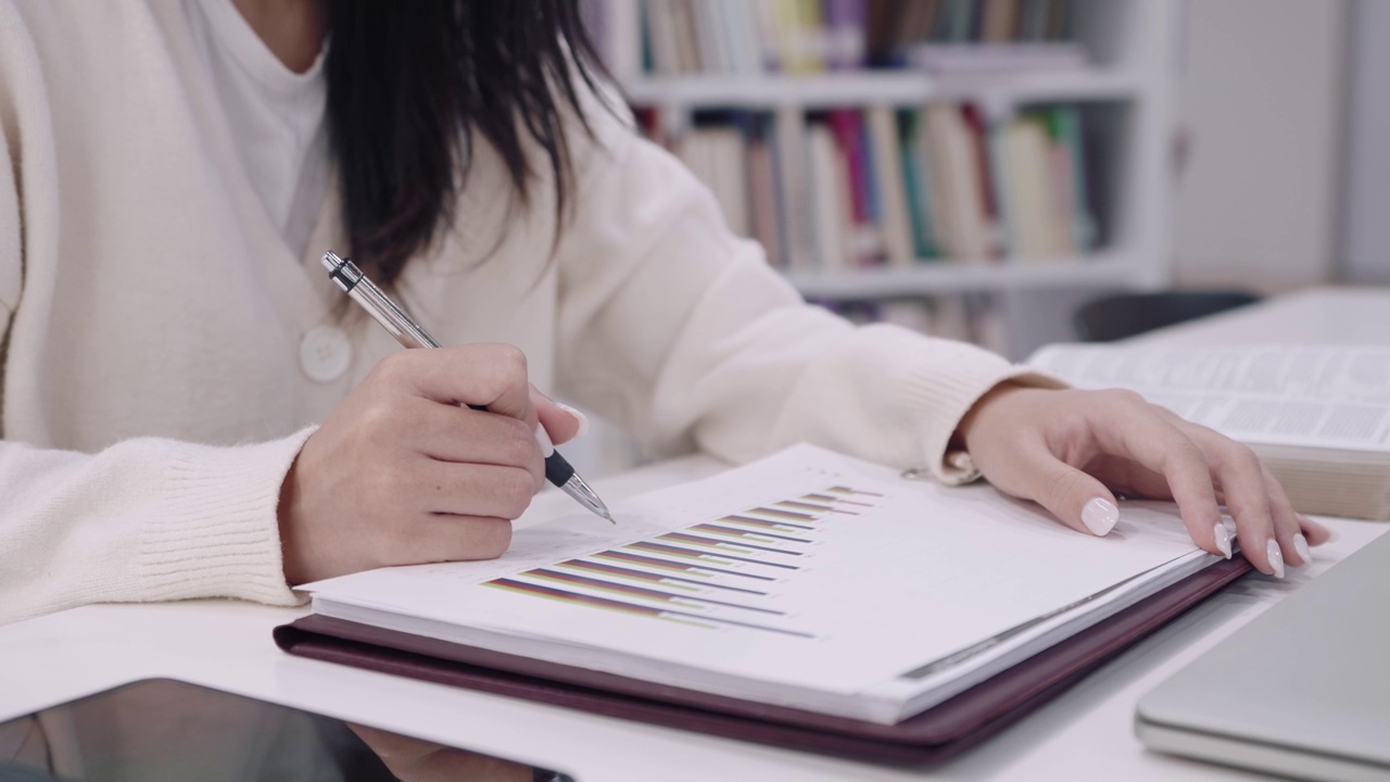 亚洲女大学生正在大学图书馆认真学习和理解课程，准备作业或考试。抓住焦点。视频素材