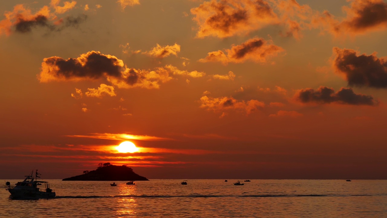 海上的日落。有渔民的渔船。船浮在海面上。由太阳光反射到水面上的光波引起的眩光。克罗地亚罗维尼——2023年11月11日视频素材