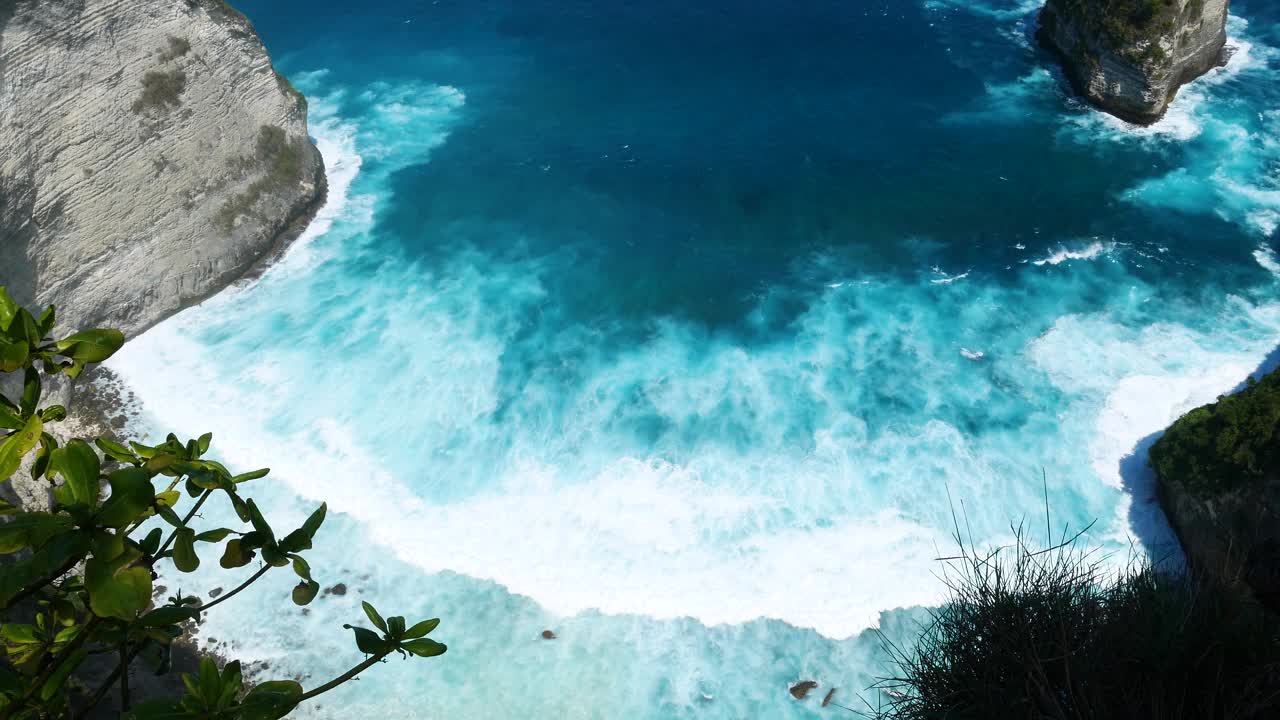 蓝绿色的海洋海水白色的波浪溅深蓝色的大海。鸟瞰怪物波浪飞溅在岩石上。热带海滩在夏季海边户外。大洋岛风景优美，引人注目。视频素材