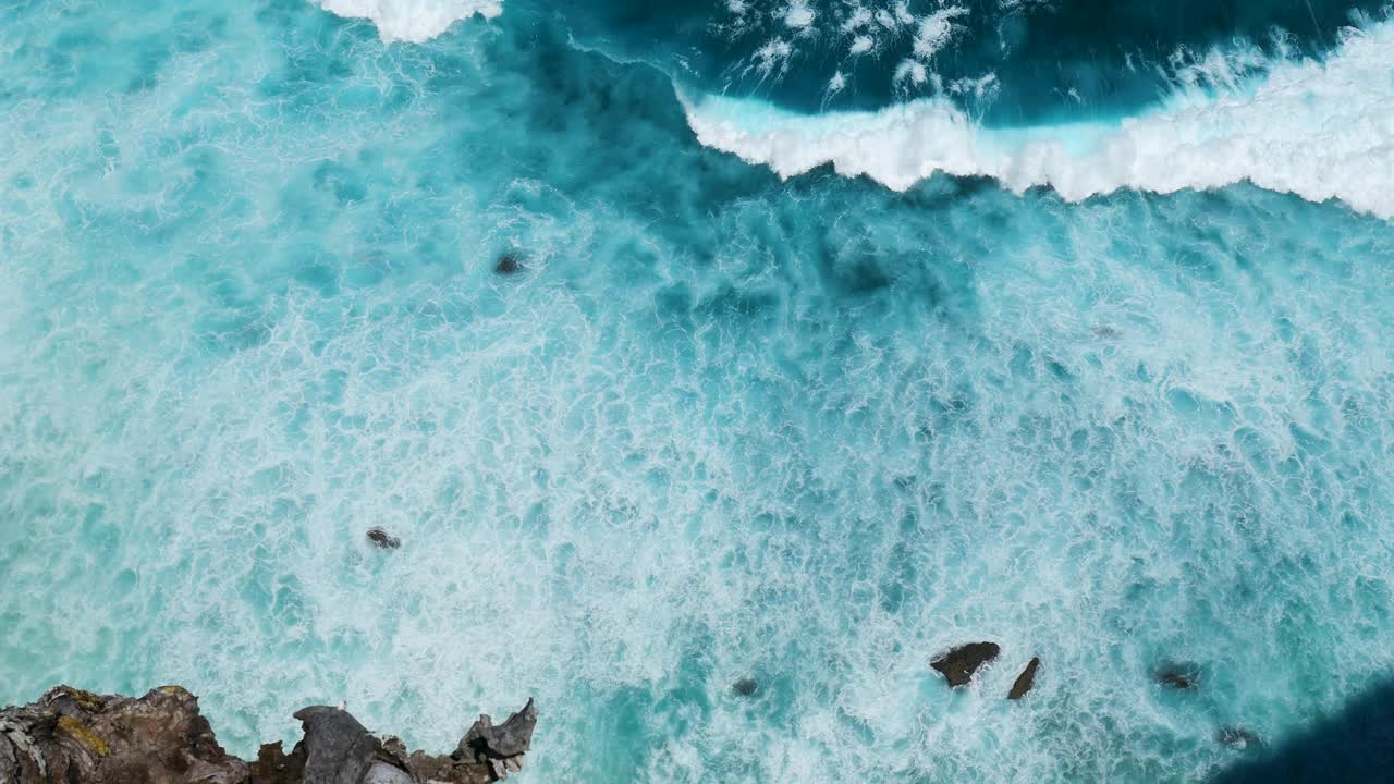 蓝绿色的海洋海水白色的波浪溅深蓝色的大海。鸟瞰怪物波浪飞溅在岩石上。热带海滩在夏季海边户外。大洋岛风景优美，引人注目。视频素材