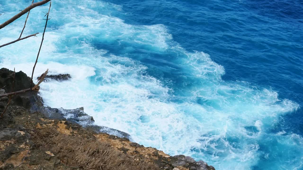 蓝绿色的海洋海水白色的波浪溅深蓝色的大海。鸟瞰怪物波浪飞溅在岩石上。热带海滩在夏季海边户外。大洋岛风景优美，引人注目。视频素材