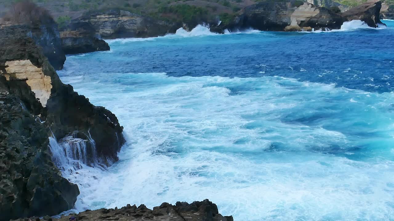 蓝绿色的海洋海水白色的波浪溅深蓝色的大海。鸟瞰怪物波浪飞溅在岩石上。热带海滩在夏季海边户外。大洋岛风景优美，引人注目。视频素材