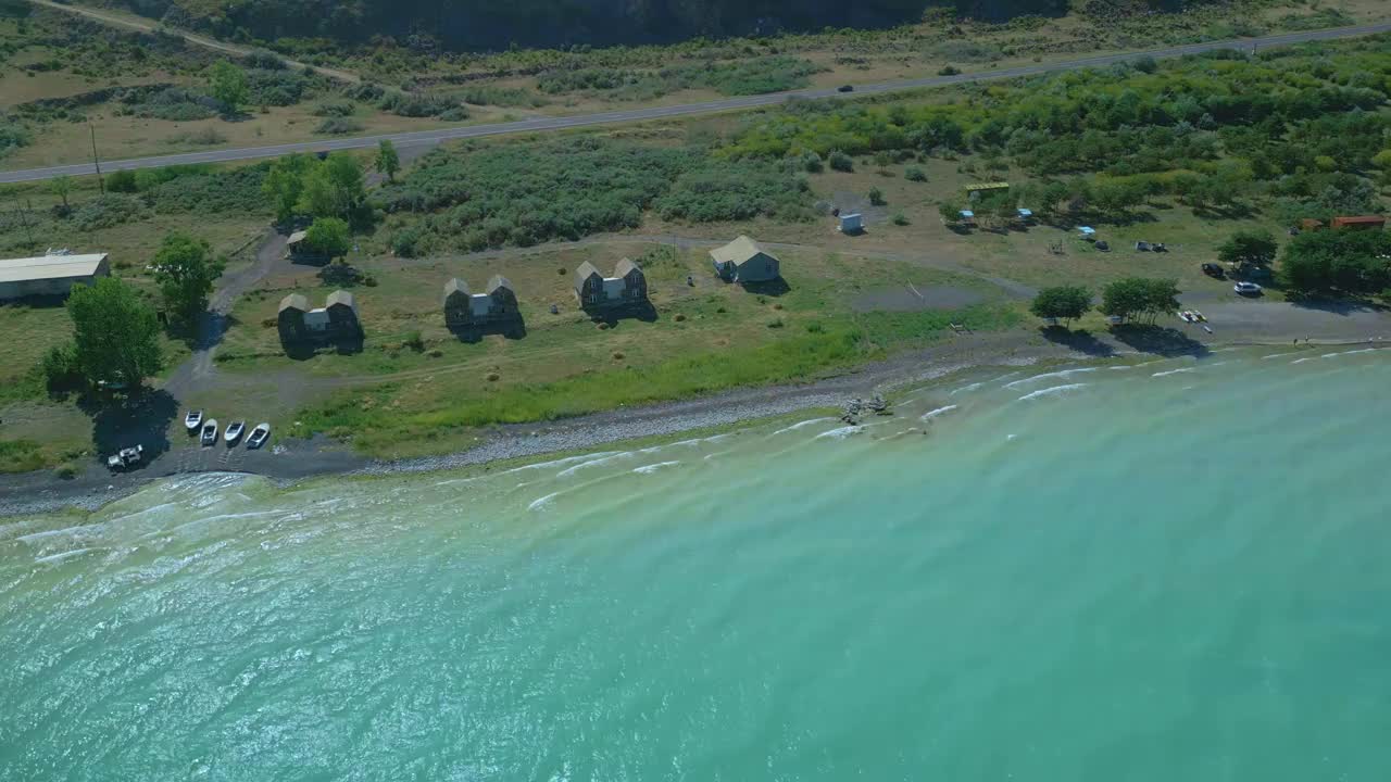 鸟瞰房屋和船只，树木，海滩大蓝色湛蓝的湖海。视频下载