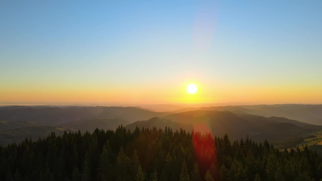 令人惊叹的山地景观。黑暗的云杉树林被黄色的夕阳照亮。在野生国家公园高地上明亮多彩的日落视频素材