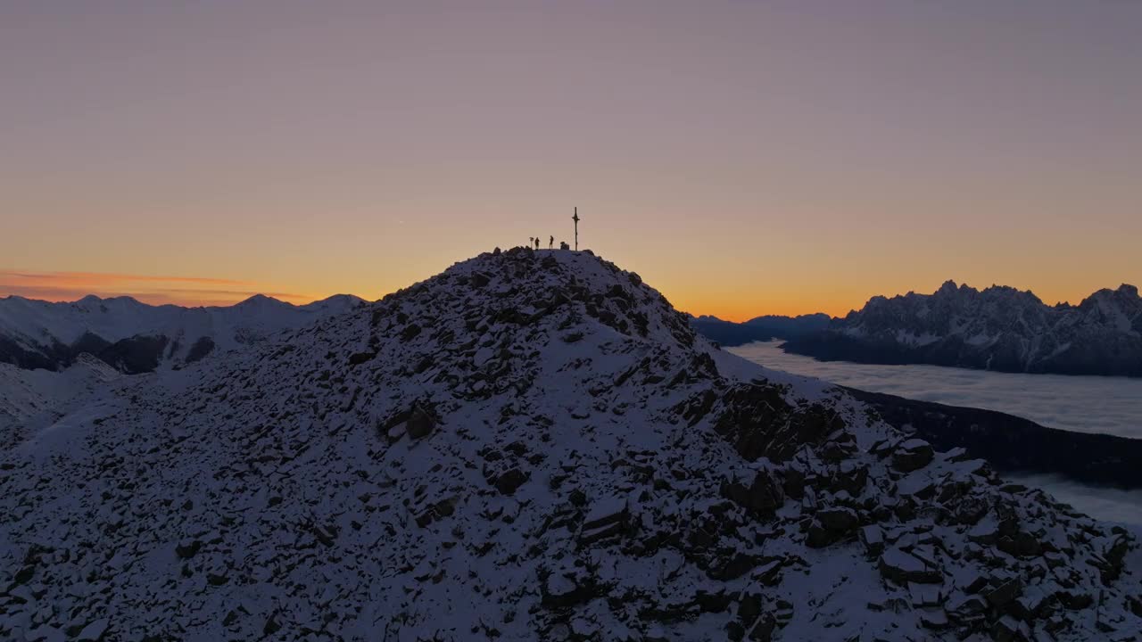 在宁静的蓝色时间里，雪山顶上的两个剪影。视频素材