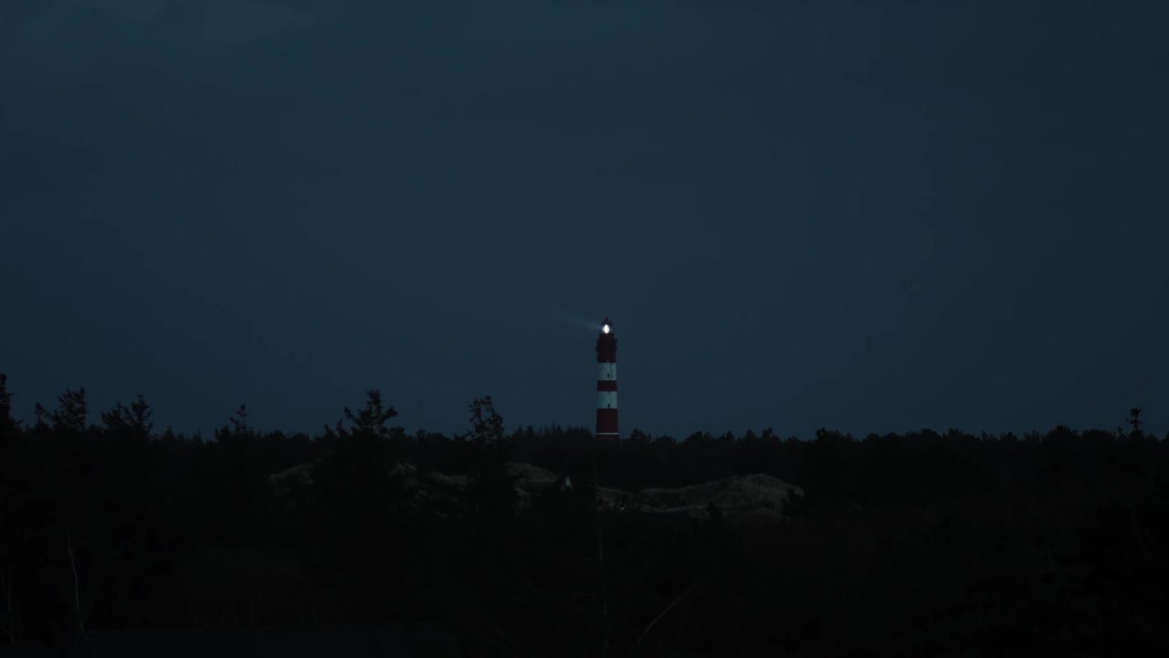 夜幕降临，远处的灯塔向大海发出信号视频素材