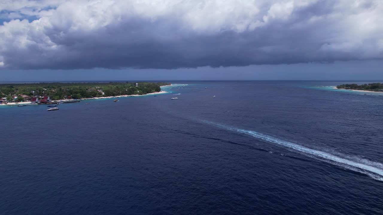 从印尼巴厘岛的Gili Trawangan鸟瞰龙目岛的Gili Meno和Gili Air。无人机在夏季阳光明媚的热带岛屿上空向后飞行。宁静度假概念。视频素材