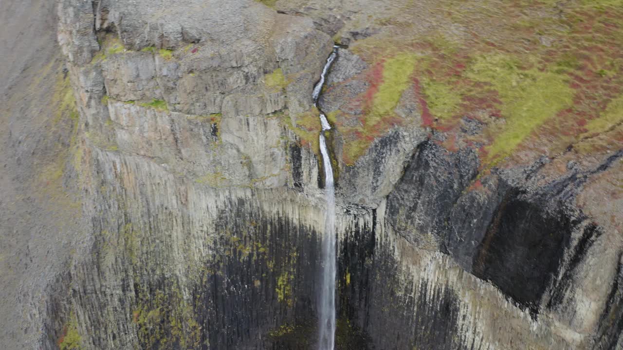 空中倒转拍摄白天冰岛火山景观中的瀑布视频素材