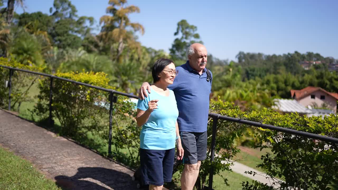 一对老年夫妇在酒店户外提着行李散步视频素材