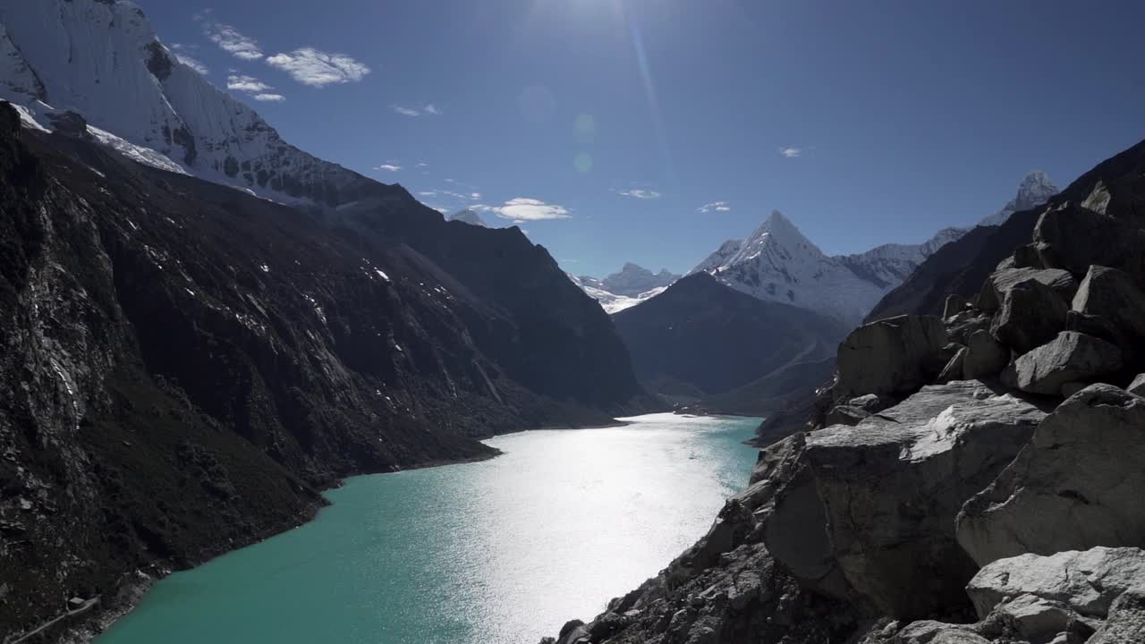 美丽的绿松石湖水在拉古纳帕隆泻湖在安第斯山脉的高山山脉在秘鲁华斯卡兰，雪山覆盖的山峰在一个明媚的阳光灿烂的一天。视频素材