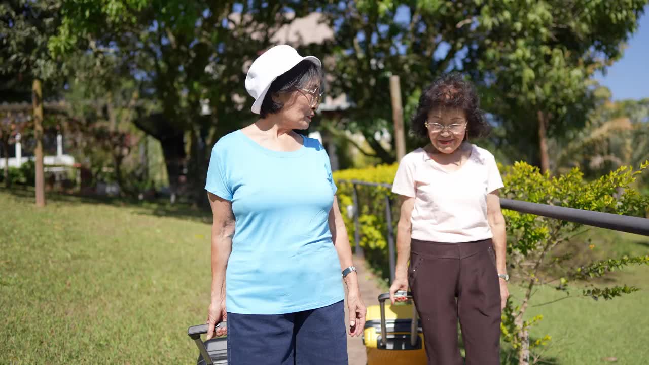 年长的朋友或姐妹在酒店里边走边聊行李视频素材