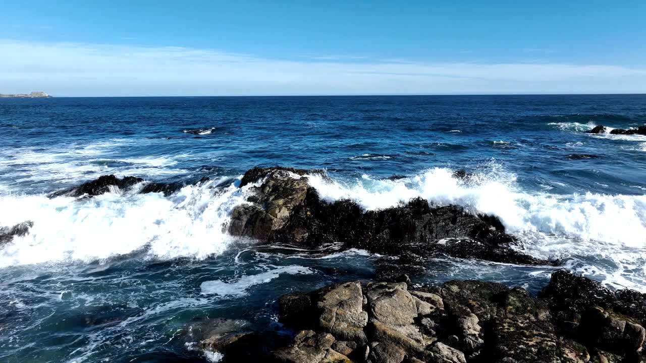 飞越智利阿尔加罗博海滩的海浪撞击岩石视频素材