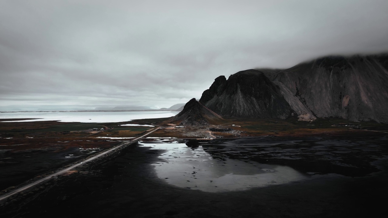 空中黑色的沙滩沙滩，山脉，远处的火山黑暗的vestrahorn，黑暗忧郁的多云景色，冰岛视频素材