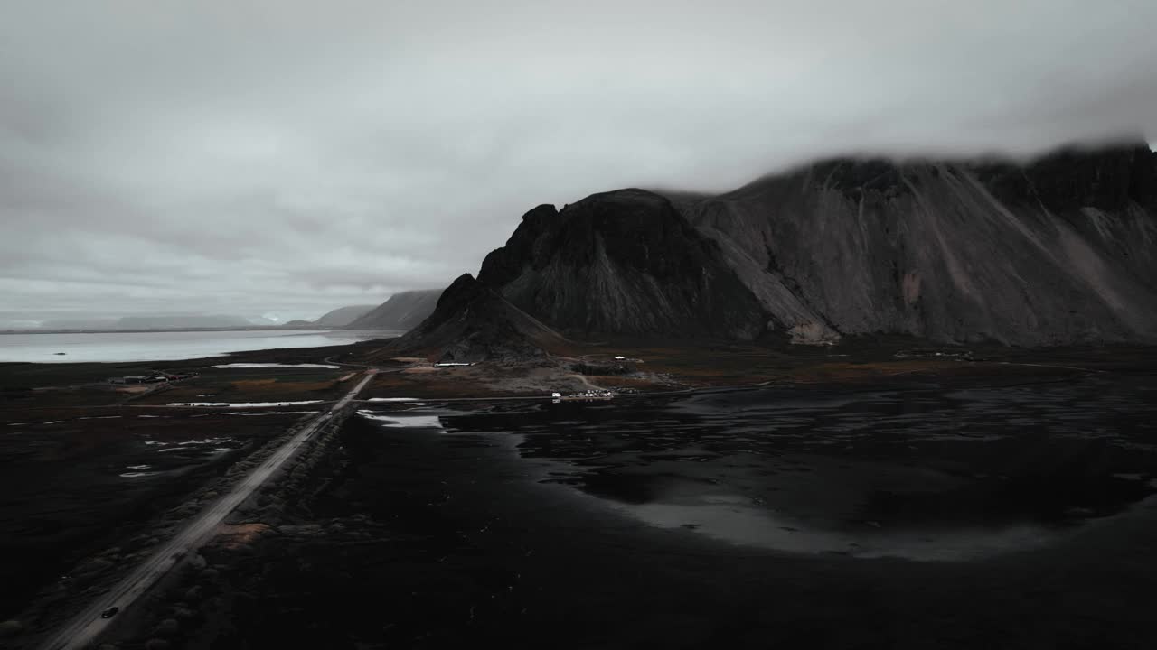 空中黑色的沙滩鹳鸟，远处黑色的火山山脉，阴沉阴沉的多云海鸥在飞翔，冰岛视频素材