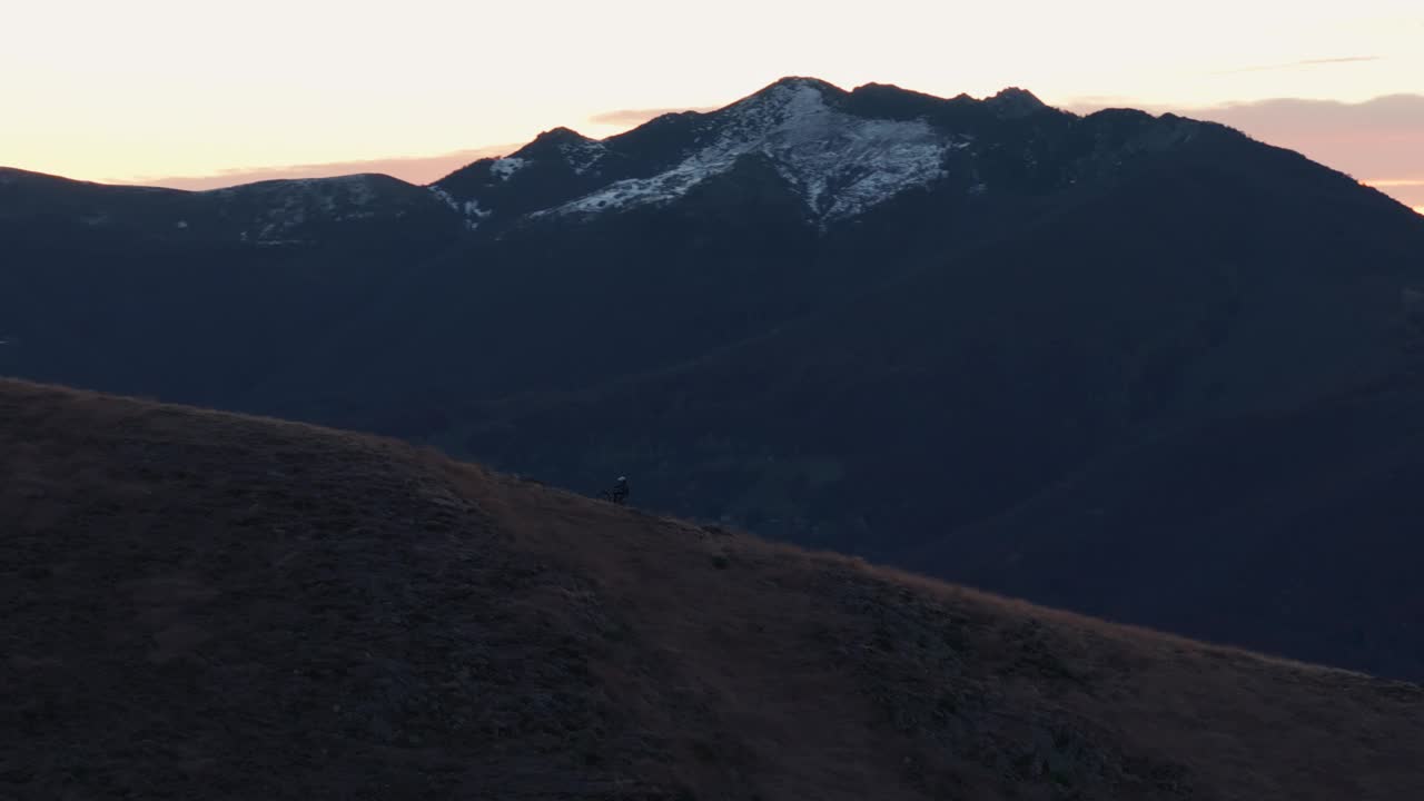 日出时骑山地自行车的人沿着山脊山脊骑行视频素材