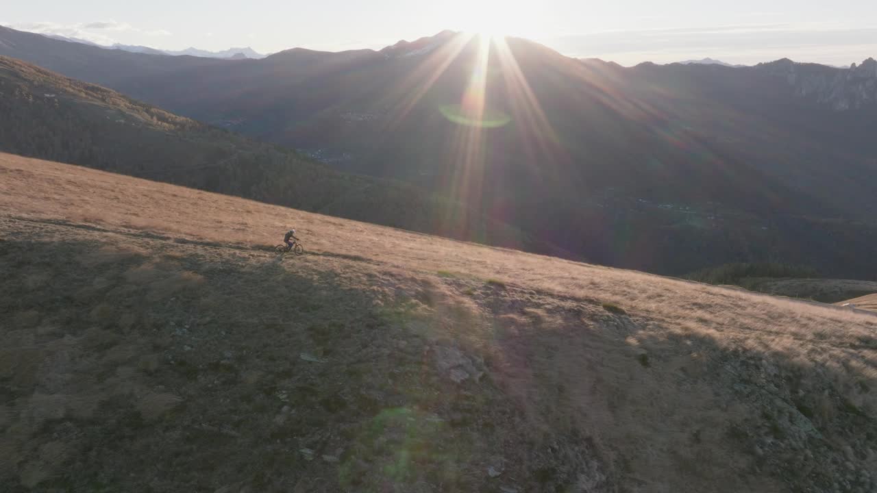 日出时骑山地自行车的人沿着山脊山脊骑行视频素材