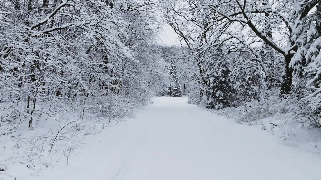 暴风雪过后，一架无人机在乡间的土路上缓缓飞行视频素材