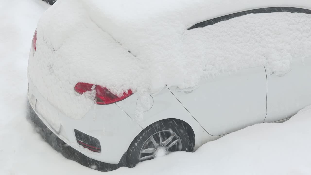 大雪扫过街道上的白色汽车。天气灾害。全球气候变化。紧急状态视频下载