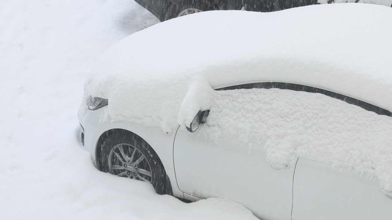 大雪扫过街道上的白色汽车。天气灾害。全球气候变化。紧急状态视频素材