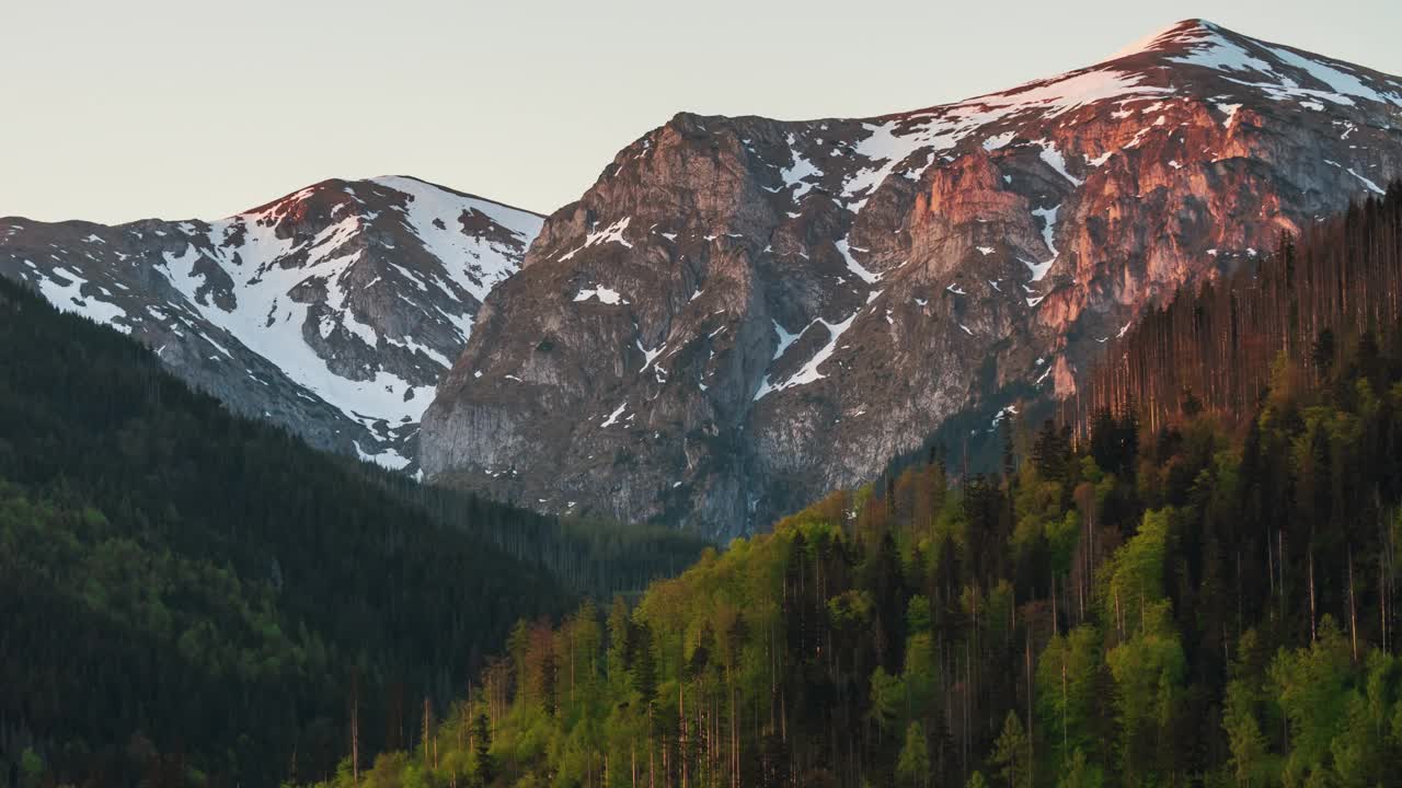 清晨的日出延时越过高山，白雪覆盖山脉视频素材