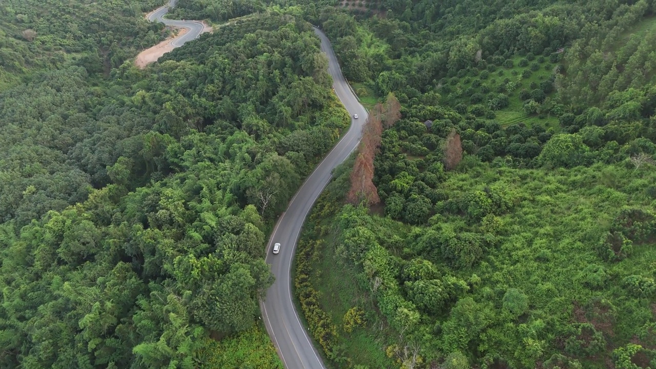 在泰国北部的清莱省，白色汽车行驶在山路上。视频素材