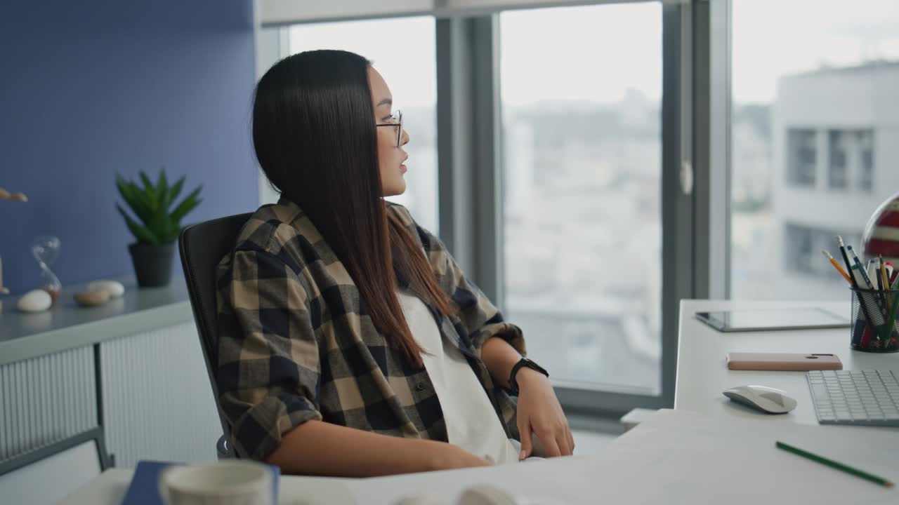 失望的自由职业者坐在办公室里看城市风景。女人味解决方案视频素材