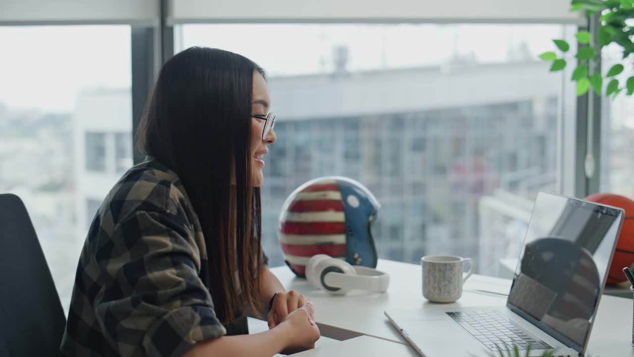 友好的自由职业者会说话的笔记本电脑在公寓近距离。做手势的女人解释视频素材