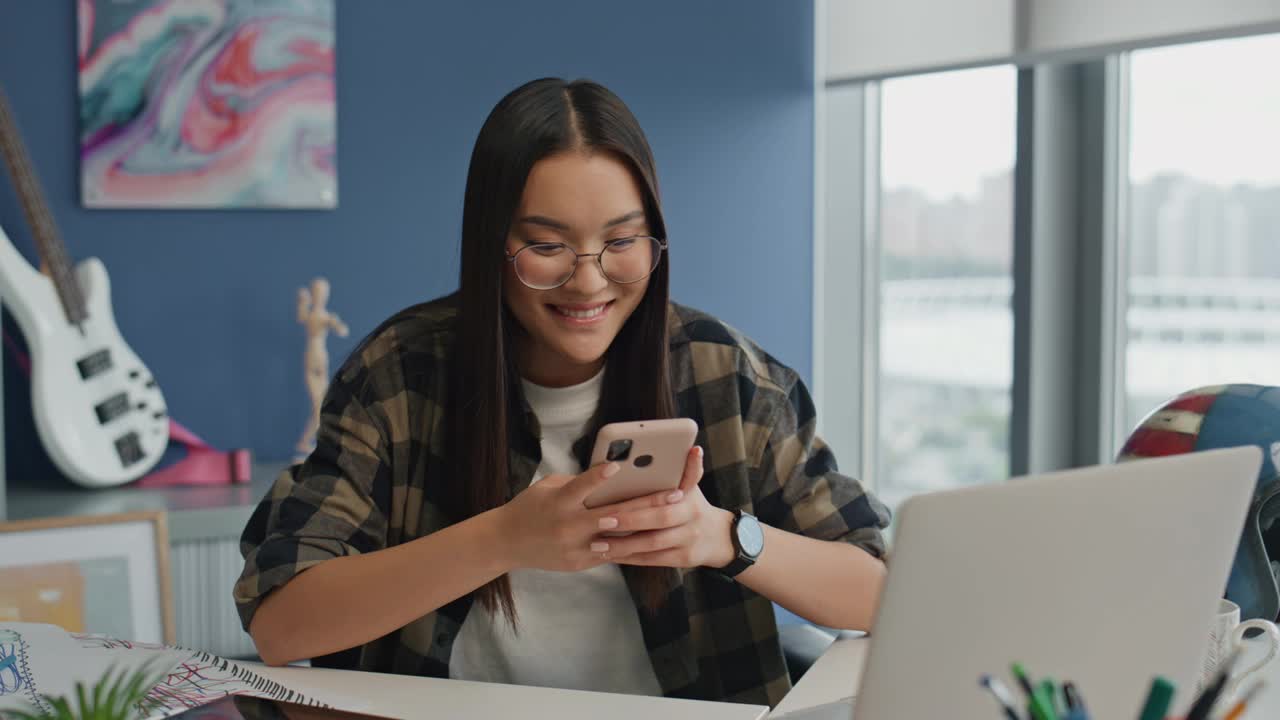 快乐的女人用智能手机发送办公室特写。微笑的女孩回复邮件视频素材