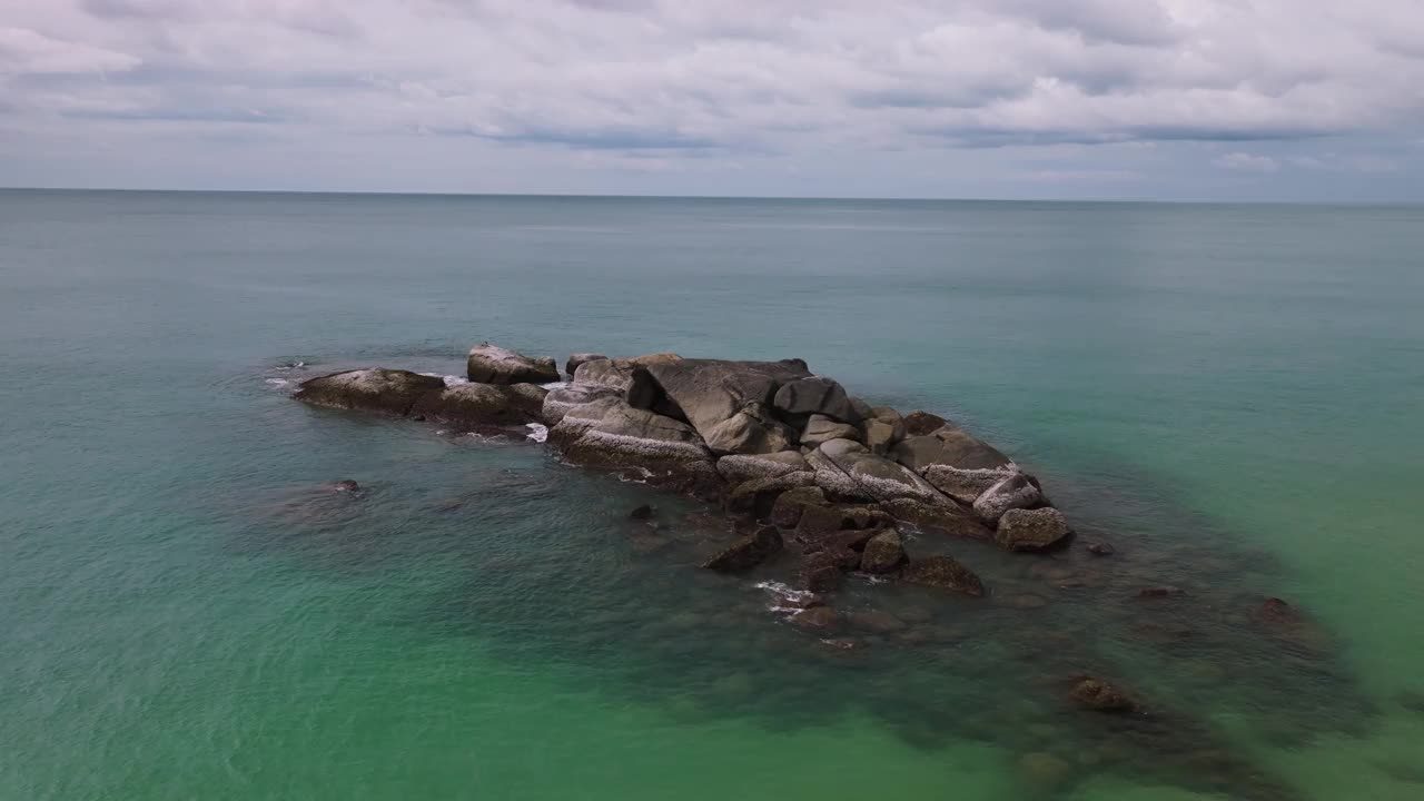 无人机视图飞行周围的岩石海岸和小波浪，海的背景视频素材