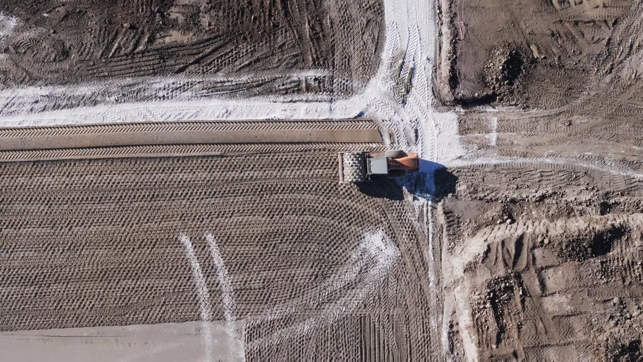 鸟瞰图:正在施工的黄色挖掘机、道路平地机、重土、在建筑工地工作的推土机视频素材