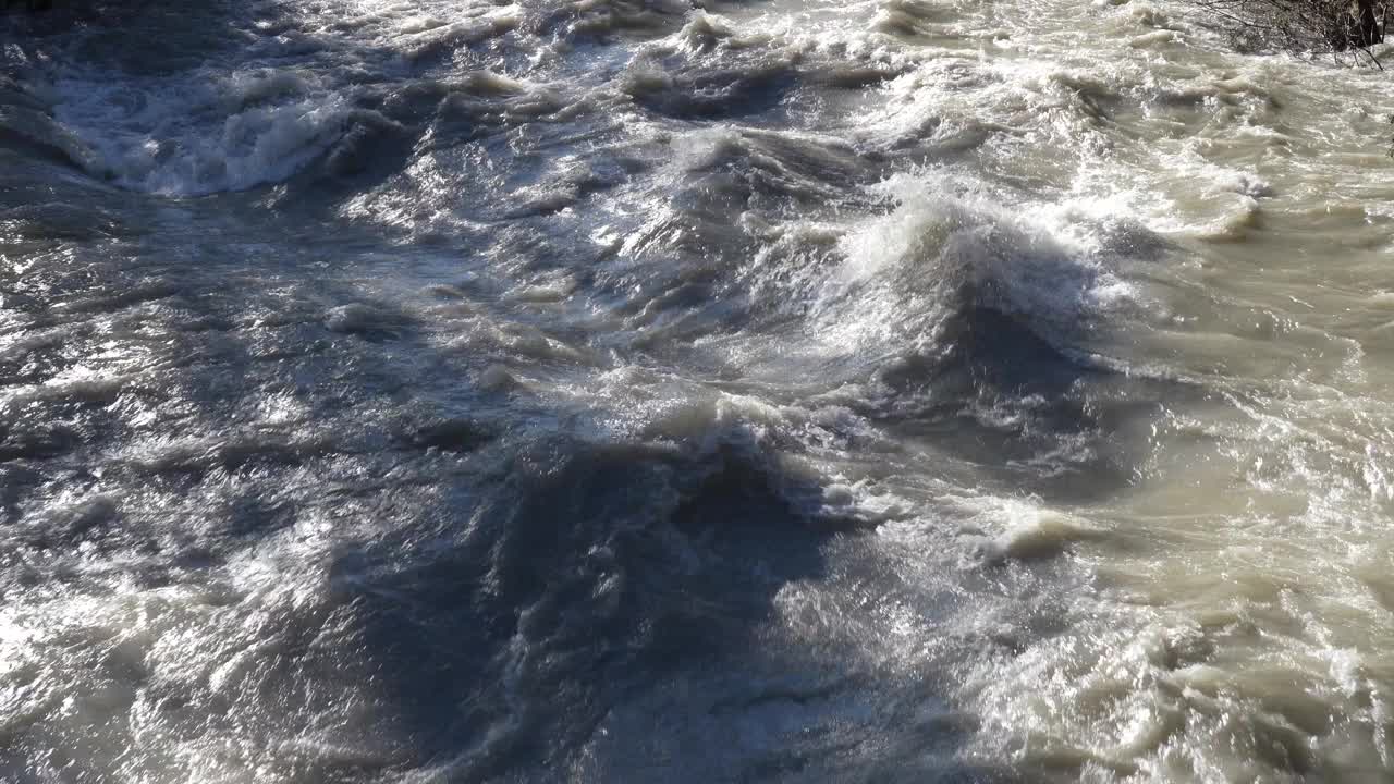 特写:暴雨和洪水冲垮山谷后，河水膨胀。水从高山谷迅速流向平原。洪水中河流的一般竞赛视频下载