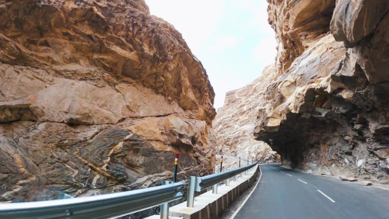 在岩石山建筑物下行驶的车辆。观点。柏油路和壮观的山景。在斯皮提谷自驾游。视频素材