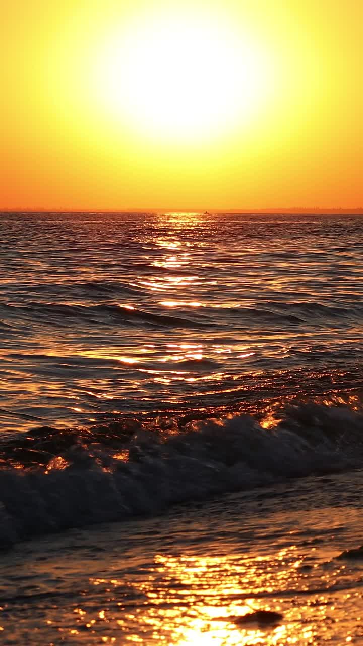 日落时的海景。波浪在落日的余晖中飞溅。视频素材