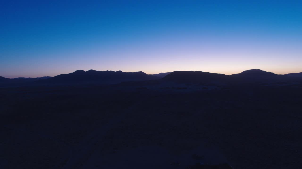 加州约翰逊谷沙漠山脉地平线的蓝色小时航拍视频下载