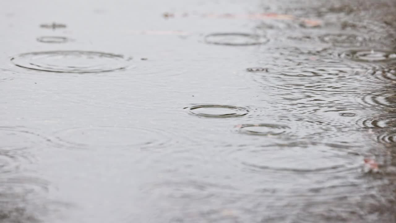 潮湿的天气场景，雨滴落在被水淹没的街道上视频素材